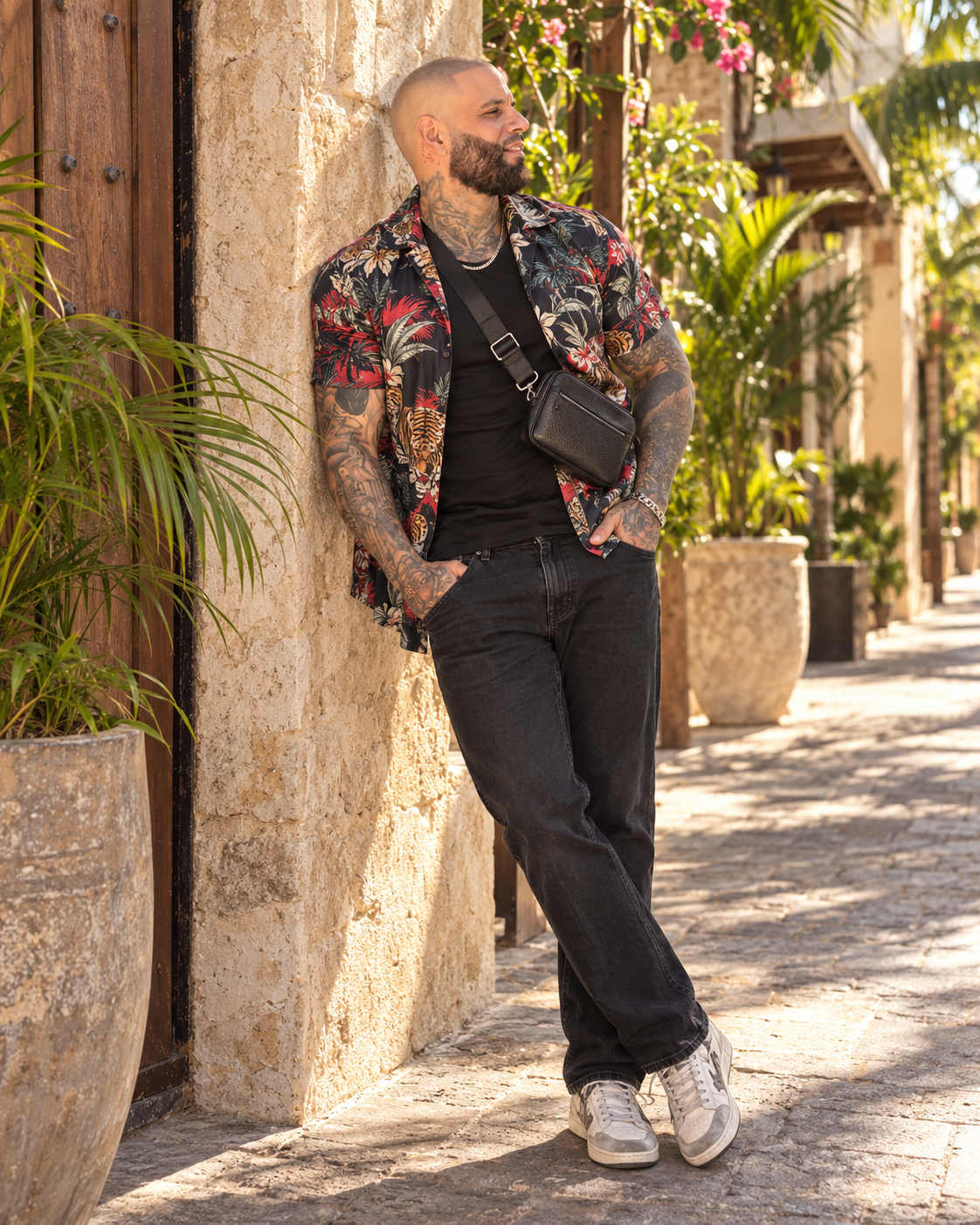 Eric in a casual vintage patterned shirt, dark jeans, sneakers and a crossbody bag